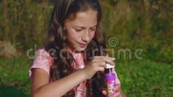 漂亮的小女孩在花园里玩肥皂泡视频的预览图