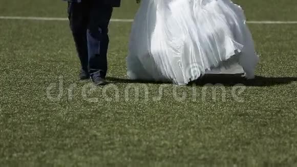 新婚夫妇在足球场上散步视频的预览图