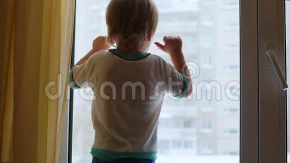 一个孩子站在窗台上望着窗外视频的预览图