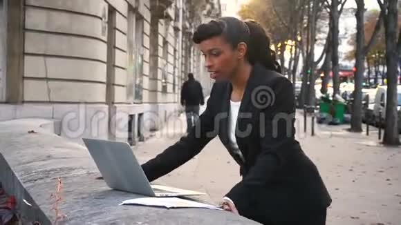 半个非洲女商人在外面用笔记本电脑打视频电话视频的预览图