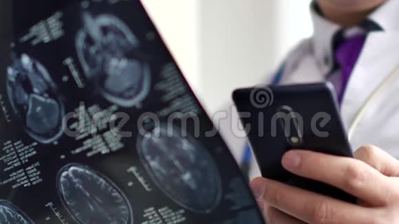 医生查看MRI扫描并给某人打短信4K超高清视频视频的预览图