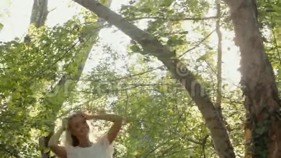 一头金发穿着一件在森林里休息的衣服视频的预览图