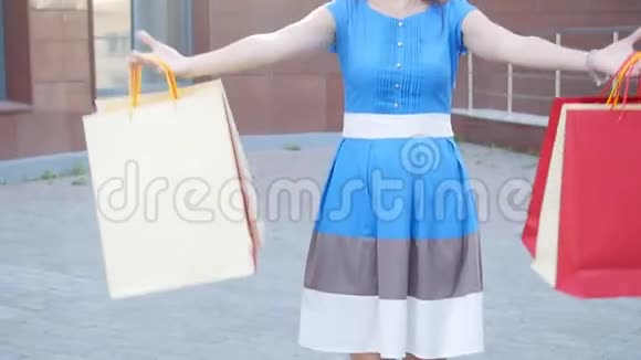 手里拿着购物袋跑着的快乐年轻女人视频的预览图