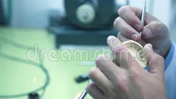 牙科技师用手术刀从义齿中取出多余的蜡视频的预览图