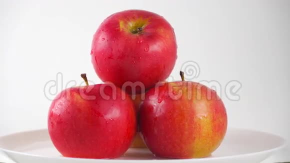 盘子里的红苹果和白色背景下的滴水4KPro的杜洛埃视频的预览图