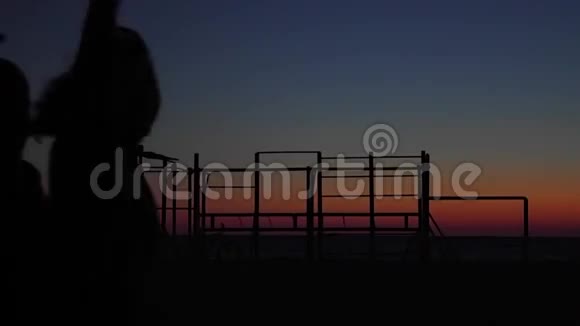 欢乐的朋友在夕阳的背景下翩翩起舞剪影式视频的预览图