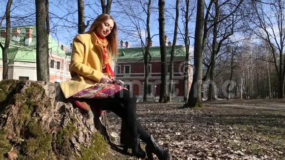 年轻女孩坐在一个古老的城堡公园里看书视频的预览图