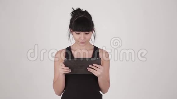 年轻迷人的拉丁裔拉丁裔女子手持平板电脑在浅灰色背景下分离视频的预览图