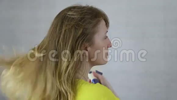 女孩用吹风机吹干头发视频的预览图