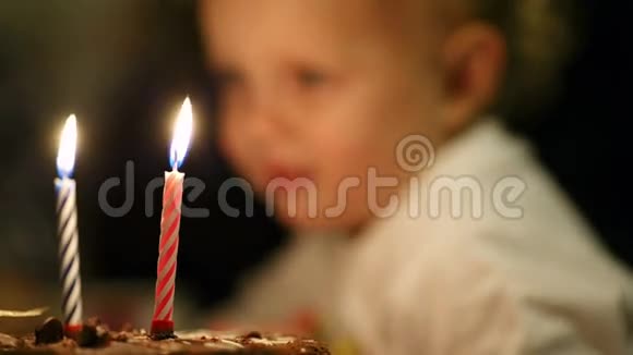 小男孩在生日蛋糕上吹了两支蜡烛视频的预览图