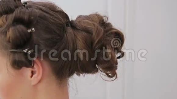近距离射击发型师为年轻女性整理发型视频的预览图