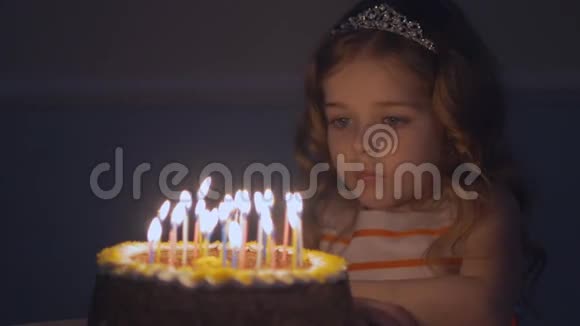 小美丽的女孩正在缓慢地在生日蛋糕上吹九支蜡烛视频的预览图