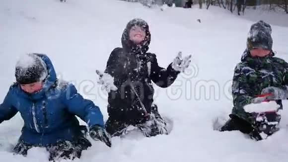 快乐的孩子们在雪地里玩耍在公园里撒雪视频的预览图