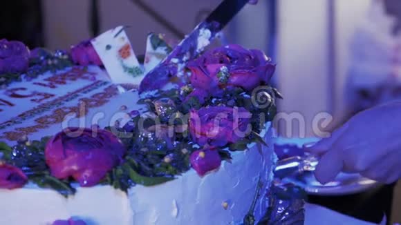 在庆祝活动中女人拿着一块巨大的蛋糕和玫瑰用刀视频的预览图