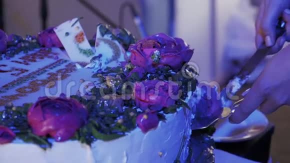 在庆祝活动中女人用刀切着玫瑰大蛋糕紫光视频的预览图