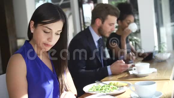 女商人在咖啡馆吃午餐和看报纸视频的预览图