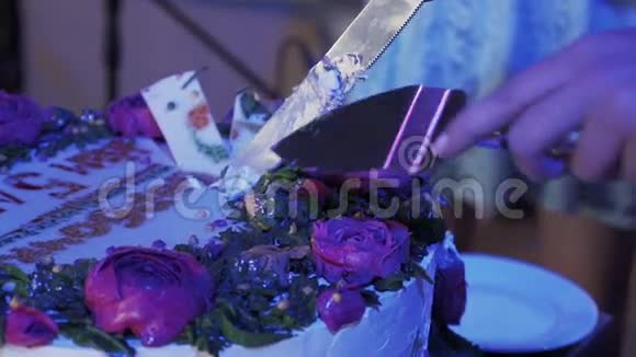 在庆祝活动中女人用两把刀切了巨大的玫瑰蛋糕紫色灯光视频的预览图