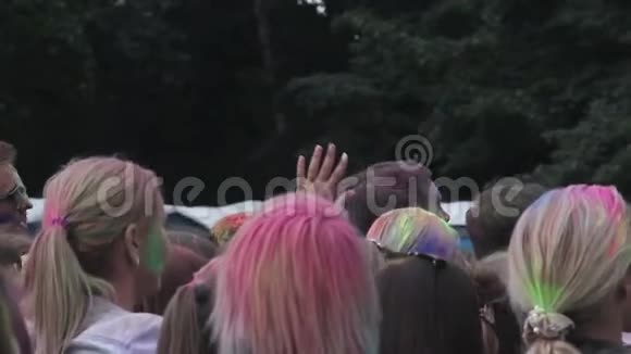 成群结队的年轻人涂满了颜料在空中撒出五颜六色的粉末来庆祝节日视频的预览图