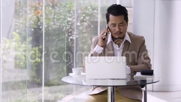 商务人士用手机和笔记本电脑说话视频的预览图