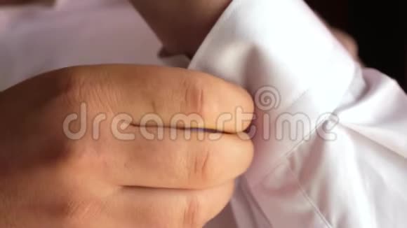 男人在白色衬衫的袖子上扣一个纽扣特写镜头商人穿上白色衬衫办公室职员视频的预览图