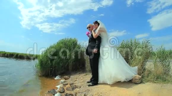 年轻美丽的新婚夫妇拥抱和亲吻视频的预览图