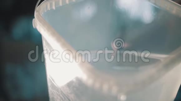 清水慢慢倒出方形透明塑料容器视频的预览图