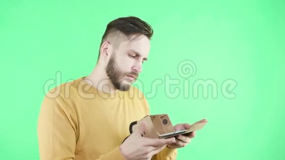 男人享受纸板谷歌VR耳机的电话视频的预览图