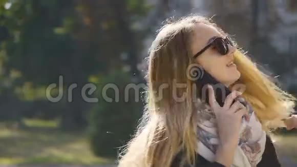 年轻的太阳镜金发女郎用电话交谈视频的预览图