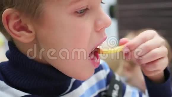 小孩在快餐店的特写镜头里吃炸土豆视频的预览图