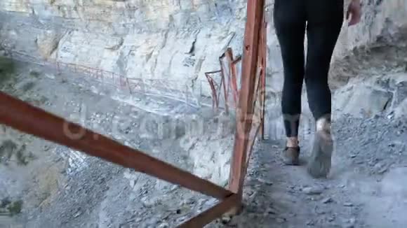 在石山小径上漫步的旅行者女性徒步旅行摄像机跟踪徒步旅行者的腿视频的预览图