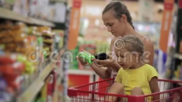 妈妈和小女儿在超市的糖果区选择零食视频的预览图