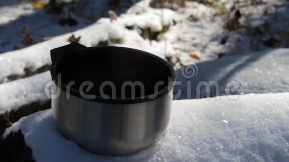站在森林的雪地上蒸杯热茶或咖啡视频的预览图