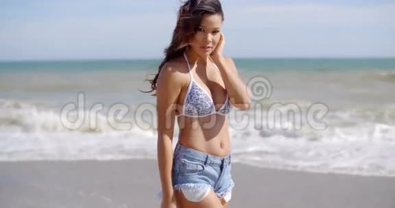 在海边穿着紧身短裤的迷人女人视频的预览图