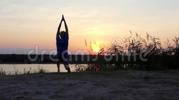 夏天日落时分年轻人在湖边练瑜伽视频的预览图