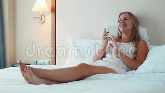 躺在床上用智能手机的金发美女视频的预览图