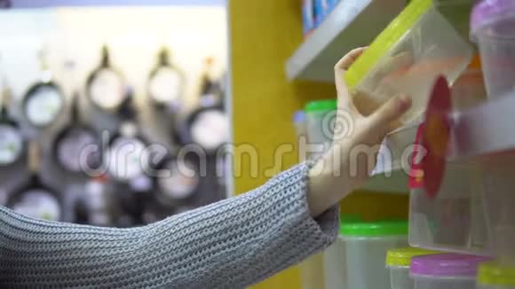 一个年轻的女人在超市里选择了一个塑料午餐盒视频的预览图