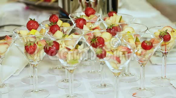 在一张白色桌子上放着草莓的玻璃杯里的水果庆祝活动特写镜头视频的预览图