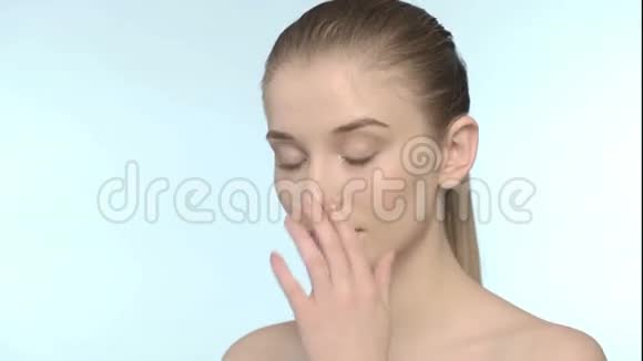 年轻迷人的女孩轻轻地用手指在脸上视频的预览图