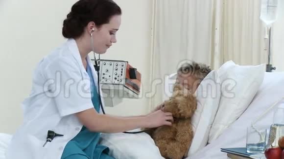 女医生在医院里和一个正在康复的小男孩聊天玩耍视频的预览图
