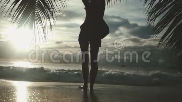 女人的轮廓越过夕阳的天空黑色的影子的女性身体与手举起来视频的预览图