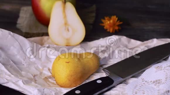 梨用刀切木桌手特写静物复古黑色背景视频的预览图