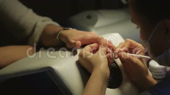 在美甲沙龙接受美容师美甲的女人美容护理理念视频的预览图