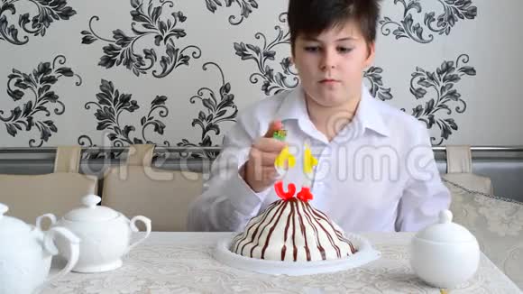 男孩用打火机在蛋糕上点燃蜡烛视频的预览图