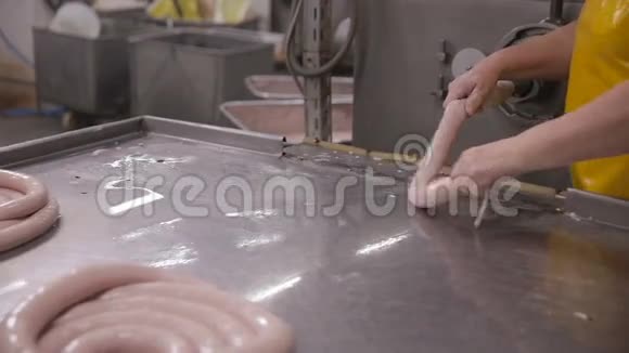 食品厂工人在自动化食品生产设备上生产香肠视频的预览图