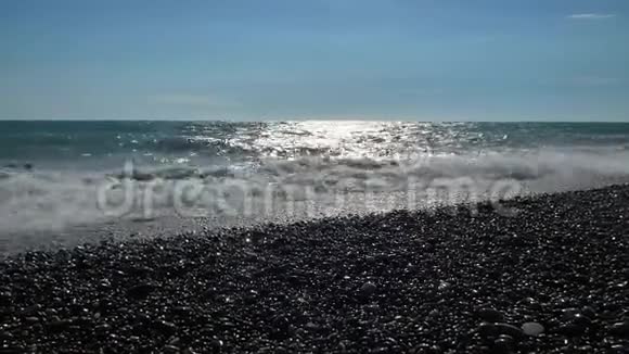 海滩上有石头和鹅卵石大的海浪会使海水刹车视频的预览图