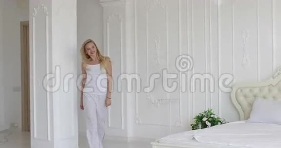 年轻的幸福夫妇拥抱女人奔跑跳过男人现代家庭卧室视频的预览图
