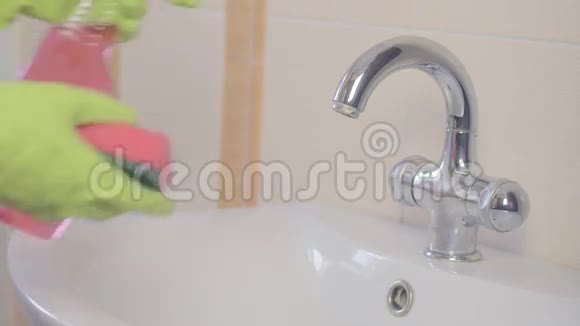 女人在家里的浴室里做家务用喷雾洗涤剂清洗水槽和水龙头序列视频的预览图