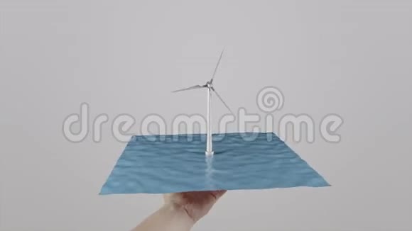 人类手中握着一个位于水面上的风力涡轮机浅灰色背景替代生态发电4K视频的预览图