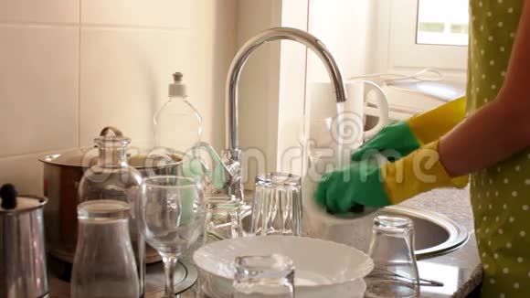 戴橡胶手套的家庭主妇洗碗视频的预览图