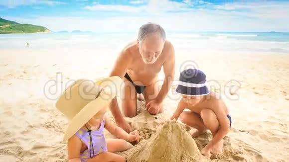 小女孩爷爷蹲在沙滩上撒沙堆视频的预览图